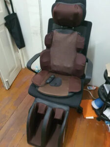 A BENBO AM607G massage chair in a home setting, showcasing its luxurious design and comfort features while in use.